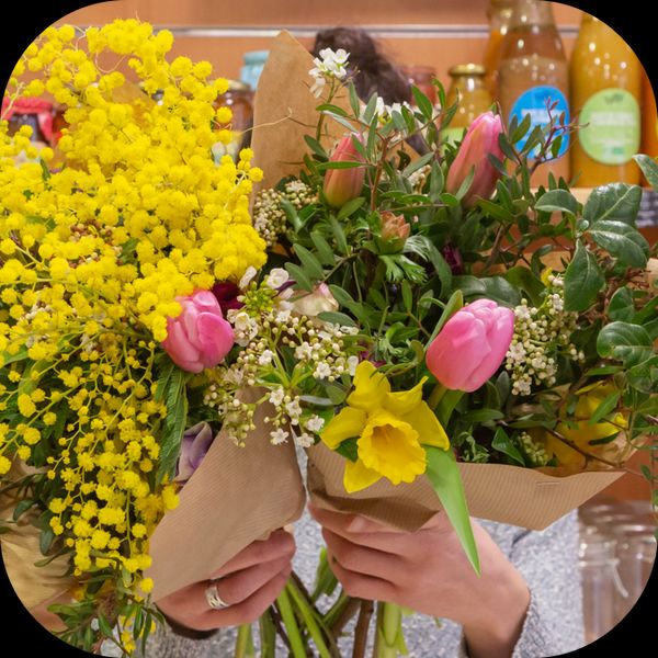 Laurine portant deux bouquets de fleurs dans ses bras