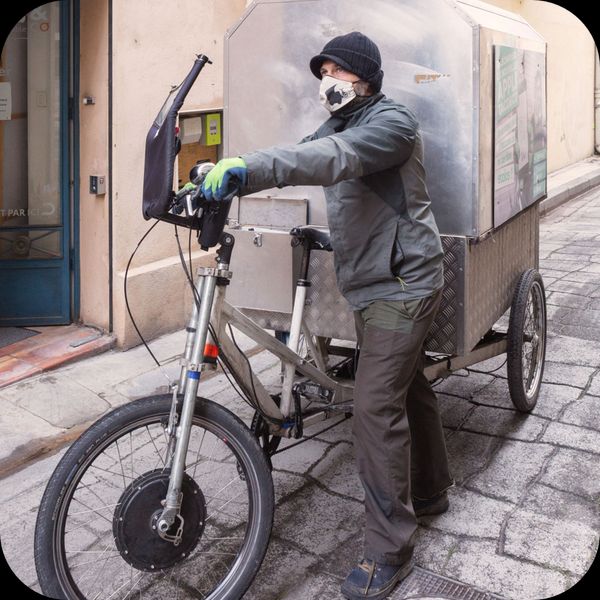 livreur de taco ans co collecte eco-responsable avec son vélo dans une rue de Arles